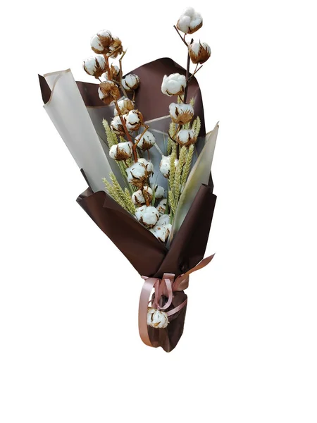 A beautiful arrangement of a bouquet of cotton and wheat flowers in a brown wrapper on a white background for clipping