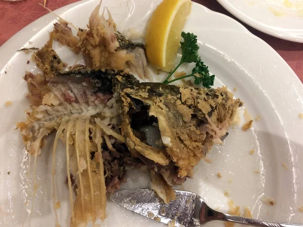 Reste Von Gebratenem Fisch Auf Einem Teller Mit Zitrone Auf — Stockfoto