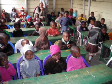 Afrikalı etnik kökenli pek çok çocuk masalarında oturuyor ve Afrika 'da bir okul ortamında eğitim görüyor.