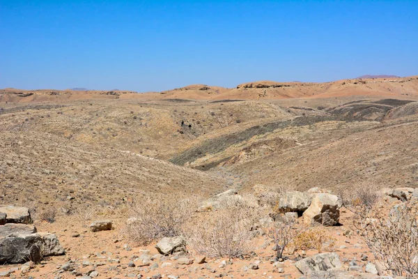在蓝天背景的映衬下 干旱的沙漠丘陵 岩石一路延伸到地平线 气候变化和全球变暖 — 图库照片