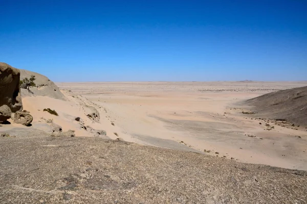 Waterless desert valley to the horizon against the background of the blue sky. World climate change and global warming