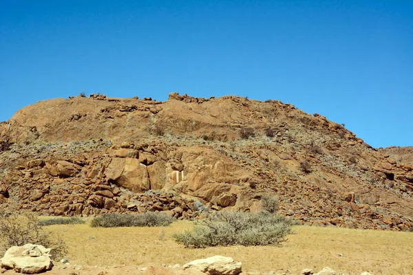 在蓝天的映衬下 沙漠中的一座棕色岩石山 世界气候变化和全球变暖 — 图库照片
