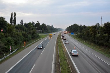 Otobanda trafik açık. Arka planda, otobanın uzaktan kumandası var. Kamyonlar ve inşaat ekipmanları kullanılıyor. Yukarıdan görüntüle