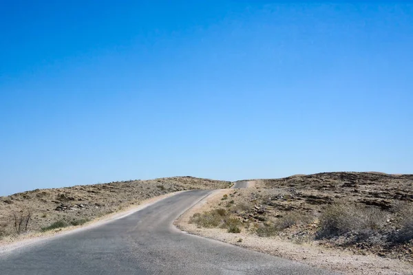 清澈的蓝天映衬着沙漠中空旷的柏油路 — 图库照片