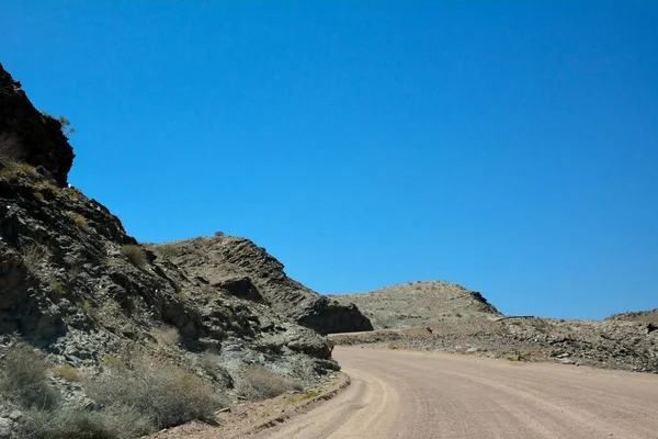 Osamělá Prázdná Asfaltová Cesta Poušti Perspektivě Proti Jasně Modré Obloze — Stock fotografie