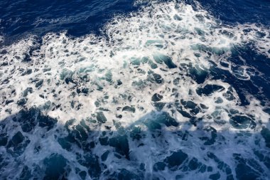 Tüm çerçeve boyunca deniz köpüklü mavi dalgaların arkaplanı. Doğal deniz arka planı ve dokusu