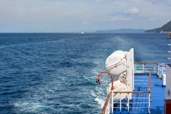 stock image View from the side of a large sea ship on the blue sea and the waves behind it