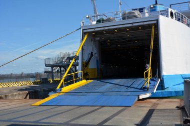 Limana büyük bir feribot yanaştı ve açık rampalı yolcu ve araçları bekliyor. Ticari ve kargo taşımacılığı