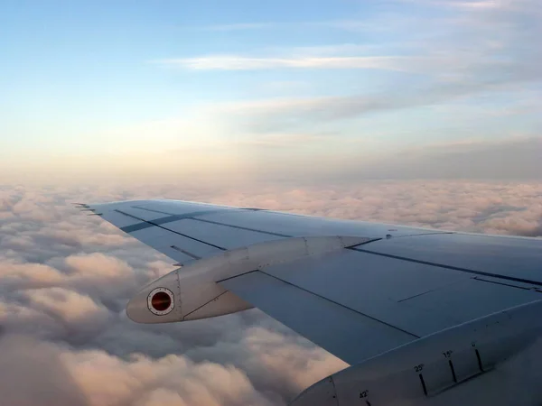 Skrzydło Samolotu Lecącego Nad Białymi Chmurami Przeciwko Błękitnemu Niebu — Zdjęcie stockowe