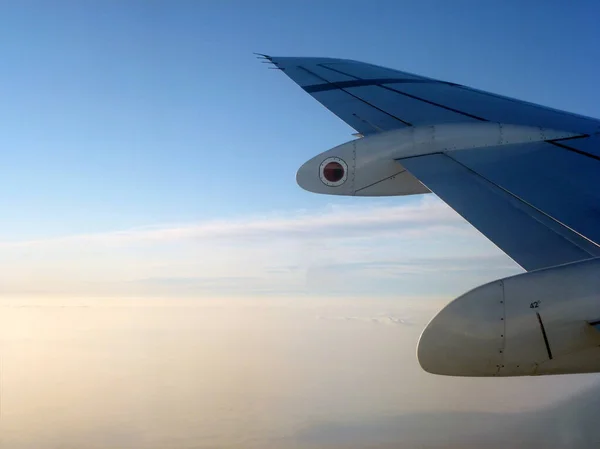 Skrzydło Samolotu Pasażerskiego Lecącego Nad Białymi Chmurami Przeciwko Błękitnemu Niebu — Zdjęcie stockowe