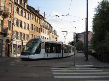 Şehrin sokaklarında eski binaların arka planına karşı modern bir tramvay çalışıyor. Eski şehirde turist gezileri