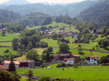 Dağ tepelerinde evler ve turist otelleri var. Yaz turist rotaları