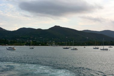 Gezinti güvertesi yelkenleri limandaki deniz kıyısına demirli. Resimli bir deniz yolculuğu.