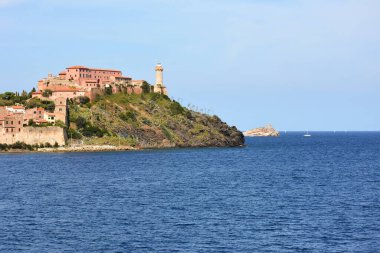 İtalya 'nın Akdeniz kıyısında, pitoresk antik binalar ve denizin arka planında eski bir deniz feneri. Avrupa Deniz Manzaraları