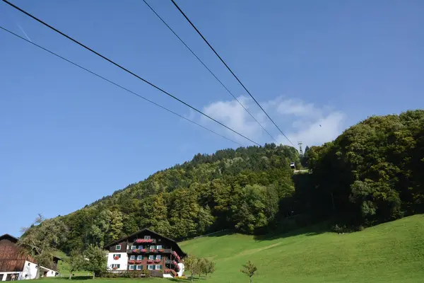 缆车从山上驶来 在旅馆的村舍附近覆盖着绿林 城市外的风景如画的自然 — 图库照片