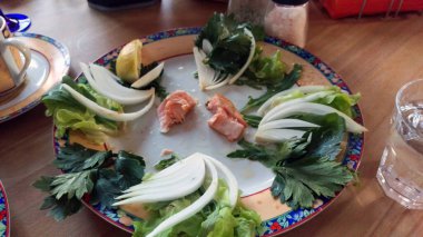 Ahşap bir restoran masasında yemek artıkları. Şarap bardakları ve çeşitli yiyecekler. Yukarıdan görüntüle