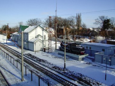 Perspektifi küçük bir şehrin altyapı binaları olan tren istasyonu. Tren görünmüyor.