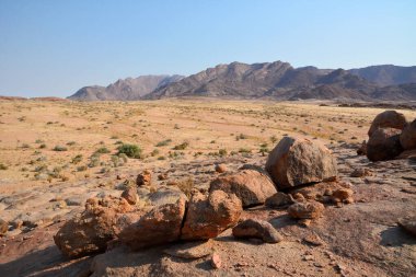 Çöl sıcak bölgesinde dağılmış kaya parçaları. Minimalizm ve doğa. Sıcak iklim ve susuzluk