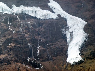 Donmuş bir dağ yamacında karlı bir buzul. Sert kuzey doğasıyla resmedilmiş kış manzarası.