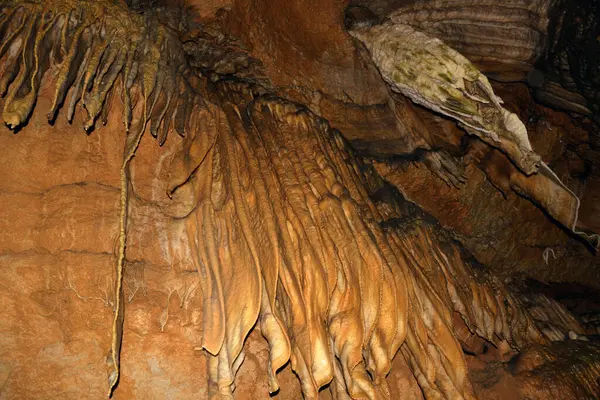 Yeraltındaki bir mağarada tavandan sarkan kil sarkıtları yakından çek. Mağara araştırmaları ve araştırmaları