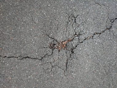 Arka planda asfalt yüzeyinde bir çatlak var. Yukarıdan görüntüle