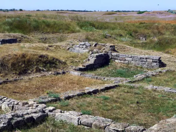 Remains of the stone foundation of an ancient building were unearthed in the field. Historical heritage in architecture.