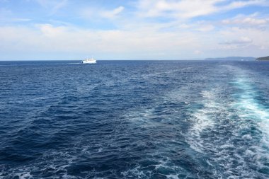 Endüstriyel gemiler mavi denizde mavi dalgalarda yelken açarlar. Gemilerin deniz trafiği ile doğal manzara