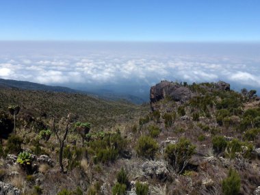 Aşağıdaki bulutların dağından ve üzerlerindeki mavi gökyüzünden güzel bir manzara. Doğal manzara.