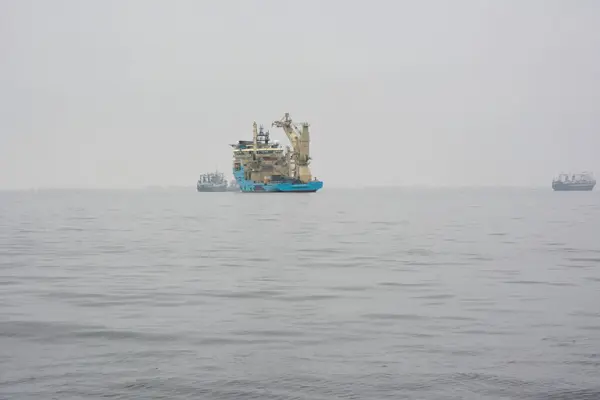 stock image An oil rig service ship floats in the sea with other ships in the distance. Maritime transport and industry