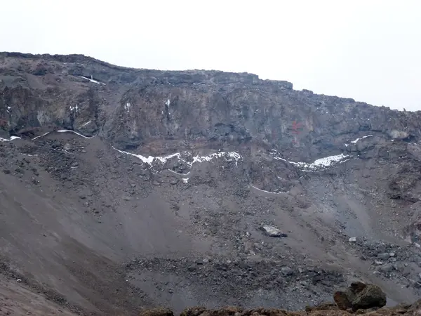 Düşen taşlarla dolu bir dağın yamacı. Bitkilerin ve ağaçların olmadığı cansız bir yer.