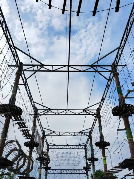 stock image Bottom view of a ropes course amusement park location in perspective without people against a blue sky background. View from below