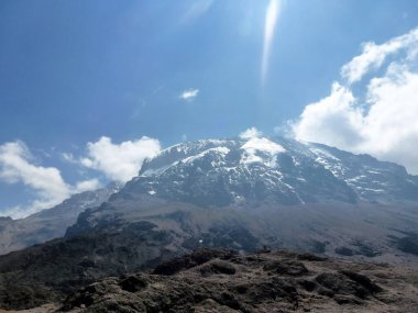 Yüksek dağın kayalık tepesi parlak mavi gökyüzünün altında beyaz karla kaplıdır. Kış resimli doğal manzara