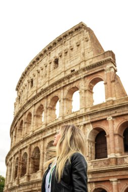 Sarışın bir kadın, İtalya, Roma 'daki antik Colosseum binasının arka planına karşı. Avrupa 'nın turistik yerleri