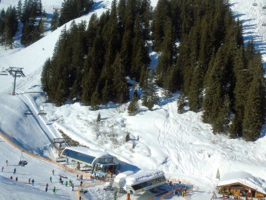 Kışın kayak merkezinin binaları, dinlenme kayakçıları ve kayak pistindeki snowboardcuların bulunduğu en iyi manzarası. Kış sporları ve eğlence