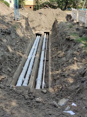 Şehrin caddesindeki evin yakınındaki acil durum kanalizasyon borularının tamiri. Kazılan çukur güvenlik çitleriyle çevrili.