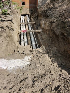 Şehrin caddesindeki evin yakınındaki acil durum kanalizasyon borularının tamiri. Kazılan çukur güvenlik çitleriyle çevrili.