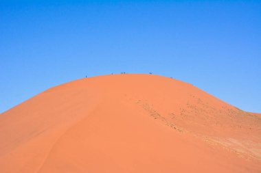 Parlak bulutlu bir gökyüzünün altında, spekülatif çöl yakınlarındaki büyük kum tepeciğinin manzarası. Kuru iklim ve küresel ısınma