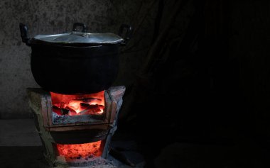 Köy tarzında, kömür sobası ve paslanmaz çelik tencere kullanarak eski moda yemek pişirmek. Uzun süre kullanılamayacak kadar kurumlu siyah. Kömür ocağı kırmızı ışık yakar, ısıtıcının kazanı vardır..