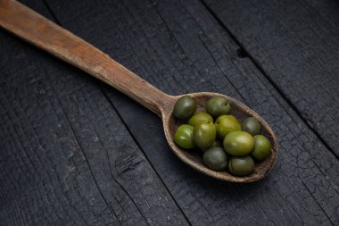 Karanlık bir arka planda sebzeli ahşap kaşık.