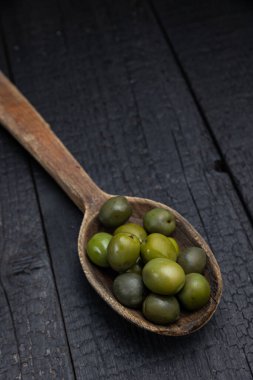 Karanlık bir arka planda sebzeli ahşap kaşık.