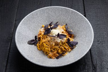 Lokantadaki karanlık bir masada lezzetli bir makarna.