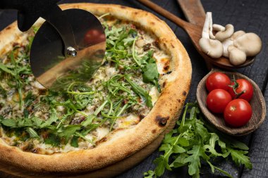 Tahta bir masada peynirli ve sebzeli lezzetli bir pizza.