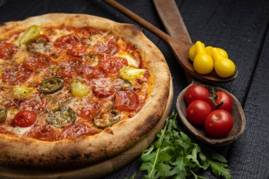 Tahta bir masada peynirli ve sebzeli lezzetli bir pizza.