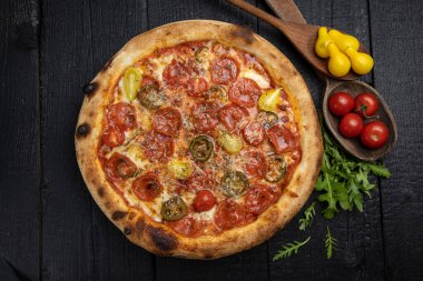 Tahta bir masada peynirli ve sebzeli lezzetli bir pizza.