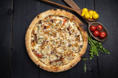 Tahta bir masada peynirli ve sebzeli lezzetli bir pizza.