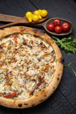 Tahta bir masada peynirli ve sebzeli lezzetli bir pizza.