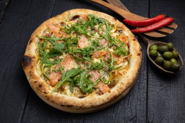 Tahta bir masada peynirli ve sebzeli lezzetli bir pizza.