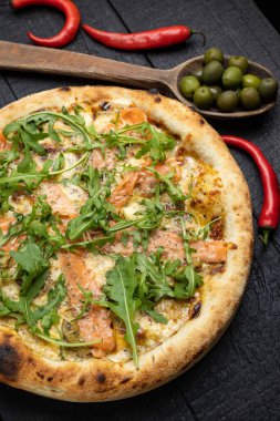 Tahta bir masada peynirli ve sebzeli lezzetli bir pizza.