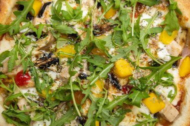 Tahta bir masada peynirli ve sebzeli lezzetli bir pizza.