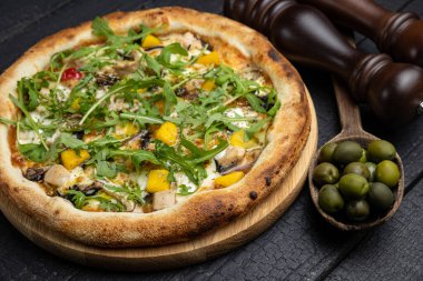 Tahta bir masada peynirli ve sebzeli lezzetli bir pizza.